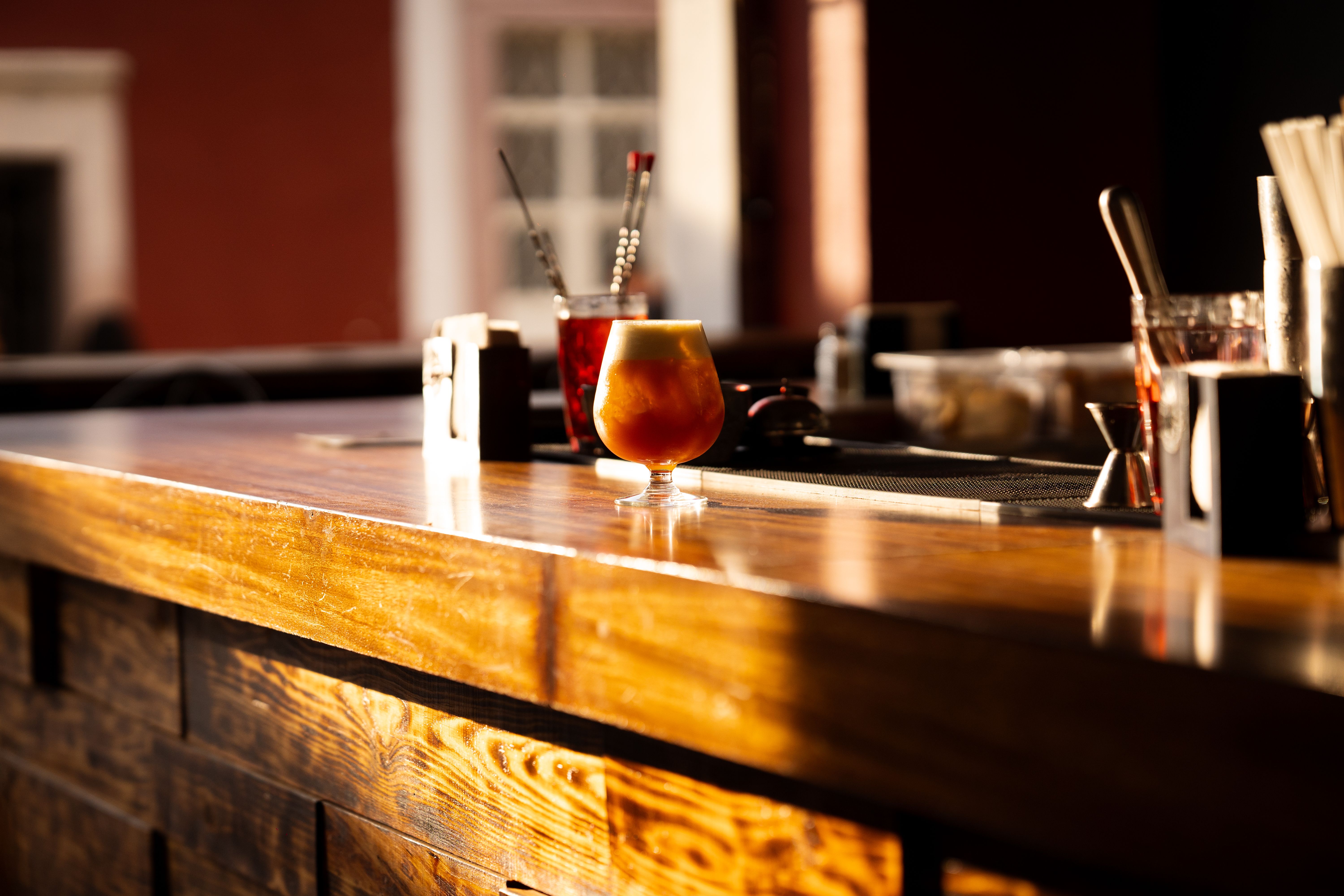Bancone di un bar al tramonto con un drink appoggiato