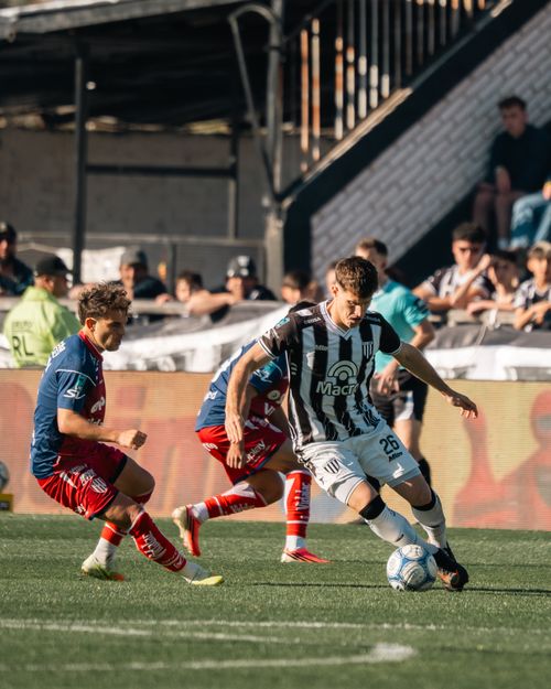 Free Soccer players in action during a lively match with an audience cheering. Stock Photo