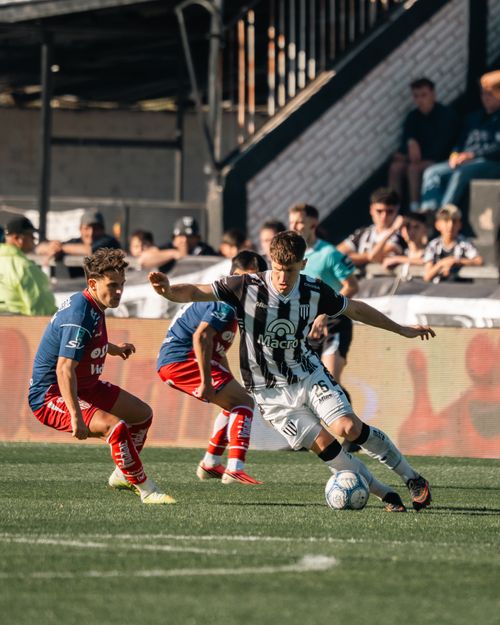 Free Players fiercely contest the soccer ball during an outdoor match. Stock Photo