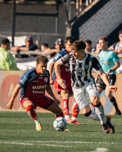Free Action-packed scene of two soccer players in a competitive match on a sunny day. Stock Photo
