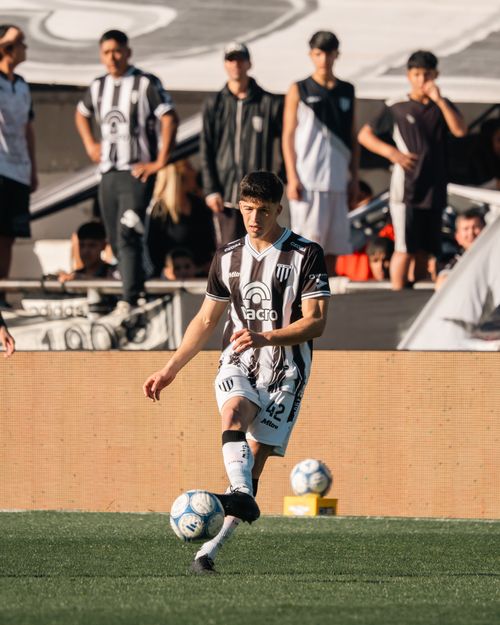Free A young soccer player in black and white uniform on the field during a daytime match. Stock Photo