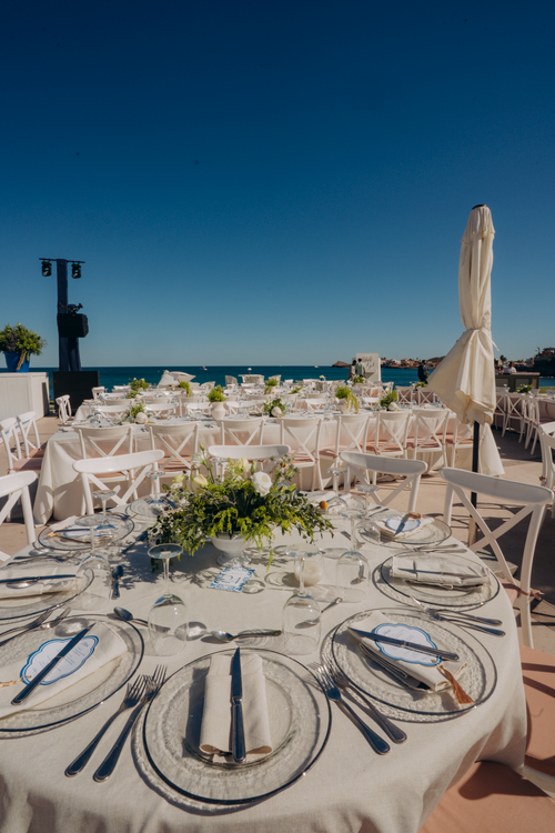 Free Outdoor beachfront wedding setup with elegant table arrangements and floral decor. Stock Photo