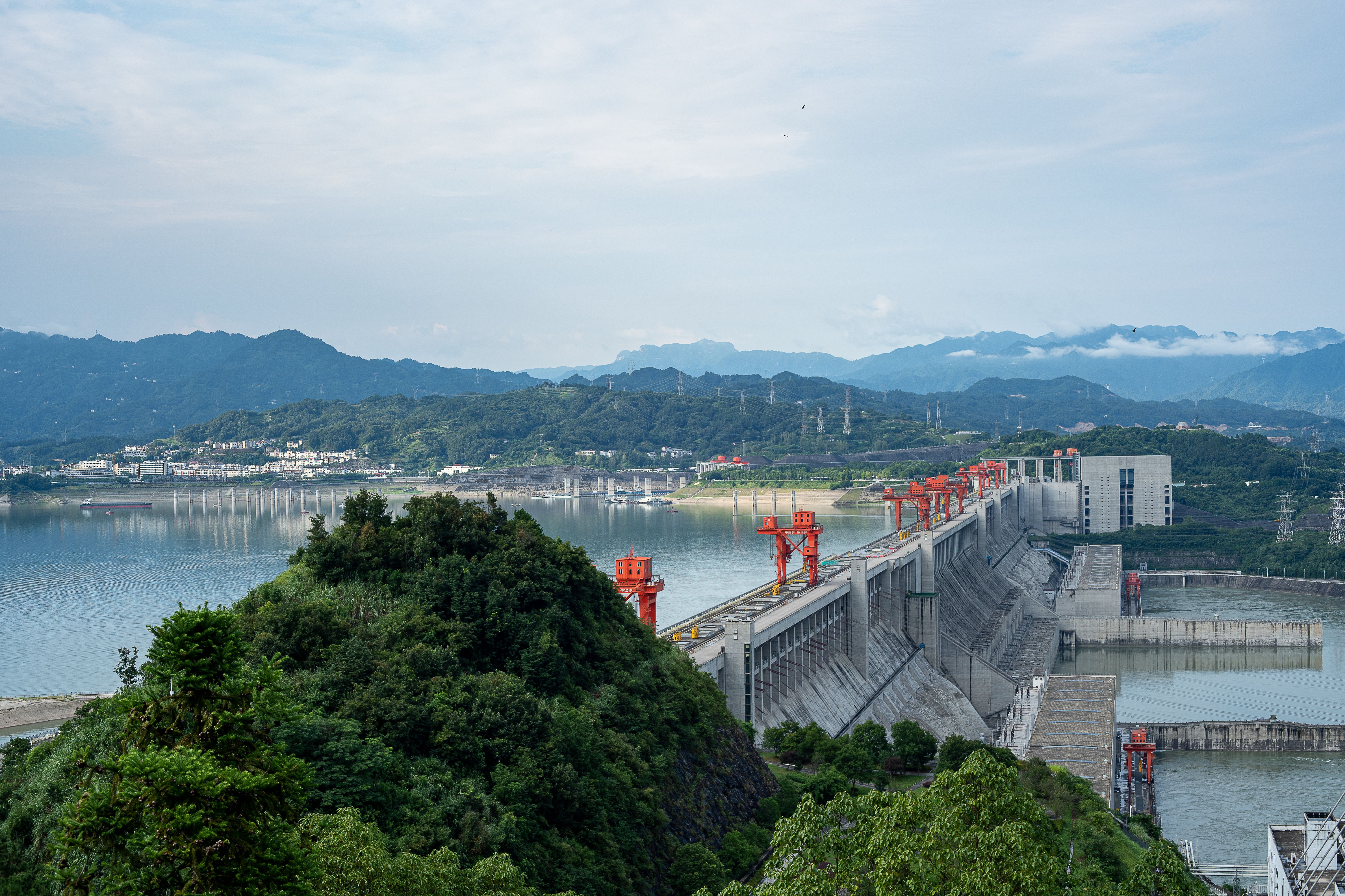 三峡ダムの壮大な建築美と周囲の貯水池を捉えた、息を呑むような空撮写真。