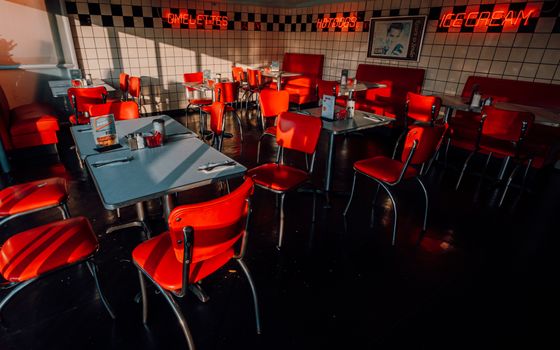 Vintage diner with red chairs and neon signs in Buenos Aires, Argentina.