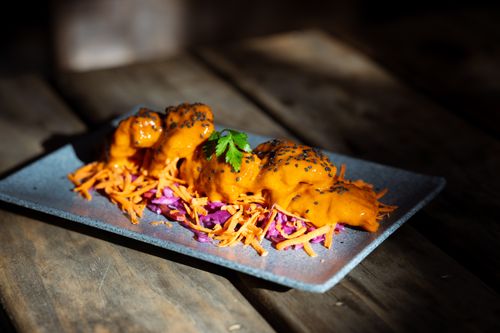 Free A gourmet dish with spicy carrot sauce topped with sesame seeds served on a stylish blue plate. Stock Photo