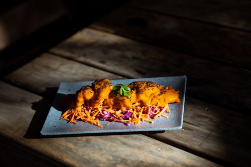 Free Elegant gourmet appetizer garnished with carrot and red cabbage on rustic wooden table. Stock Photo