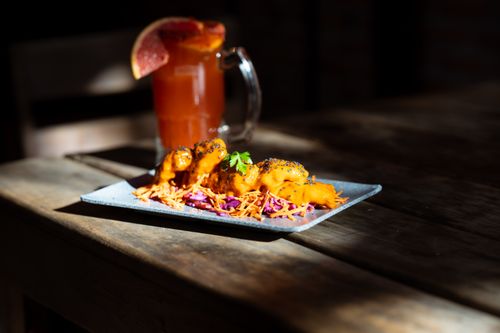 Free A gourmet dish with vibrant colors paired with an iced cocktail, creating a perfect dining experience on a rustic table. Stock Photo