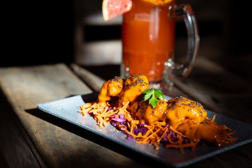 Free A vibrant spicy dish paired with a refreshing cocktail on a rustic wooden table. Stock Photo