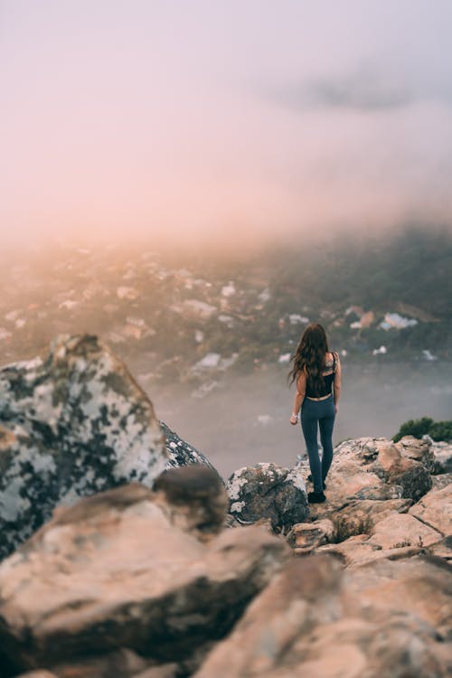 Free Woman Standing On The Edge Of A Cliff Stock Photo
