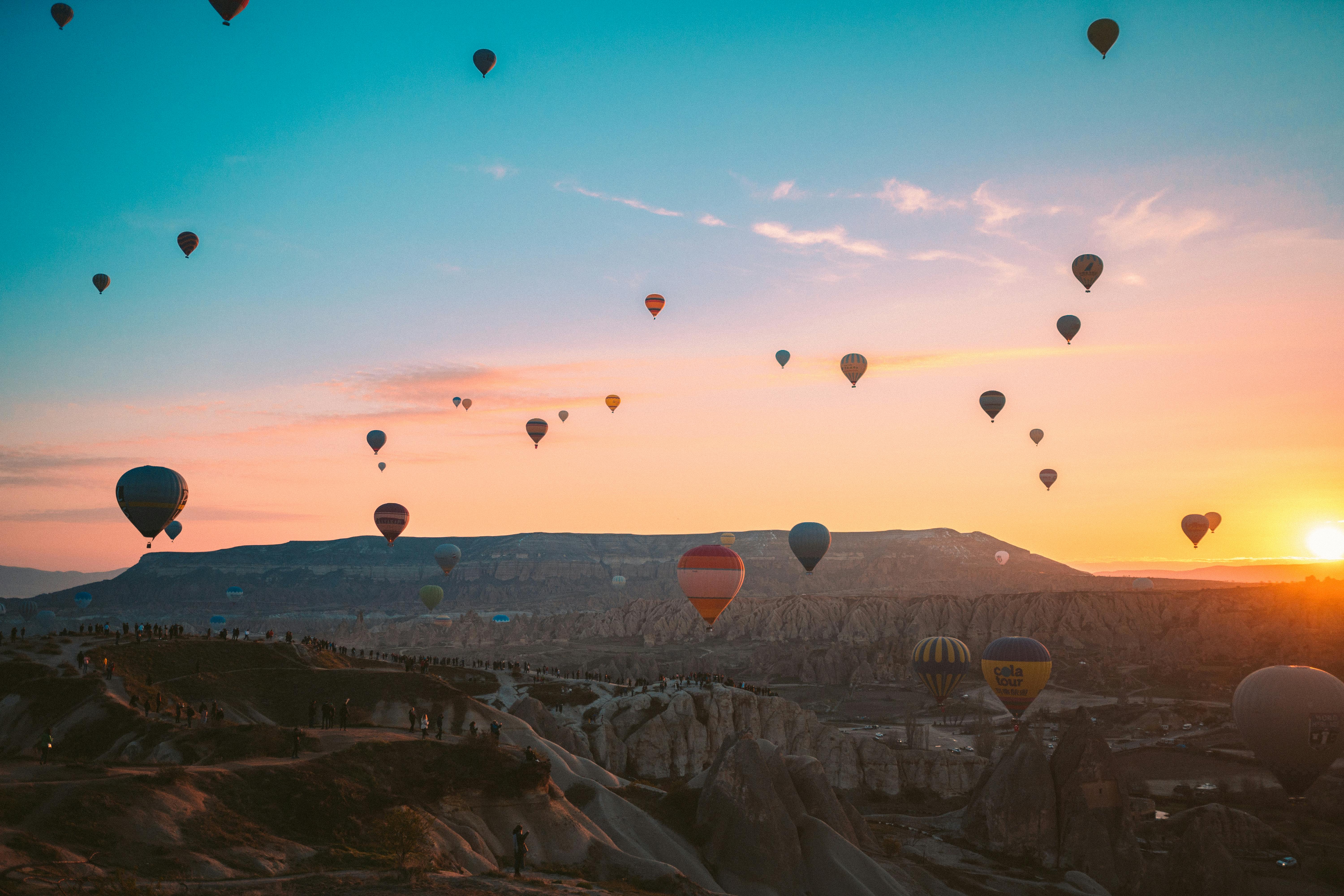 hot air balloons flying over the mountains