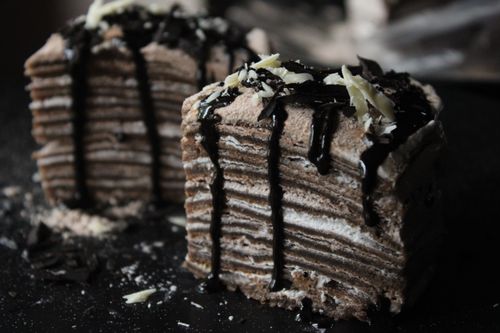 Free Stacked crepe cake with rich chocolate drizzle and shaved chocolate toppings. Stock Photo