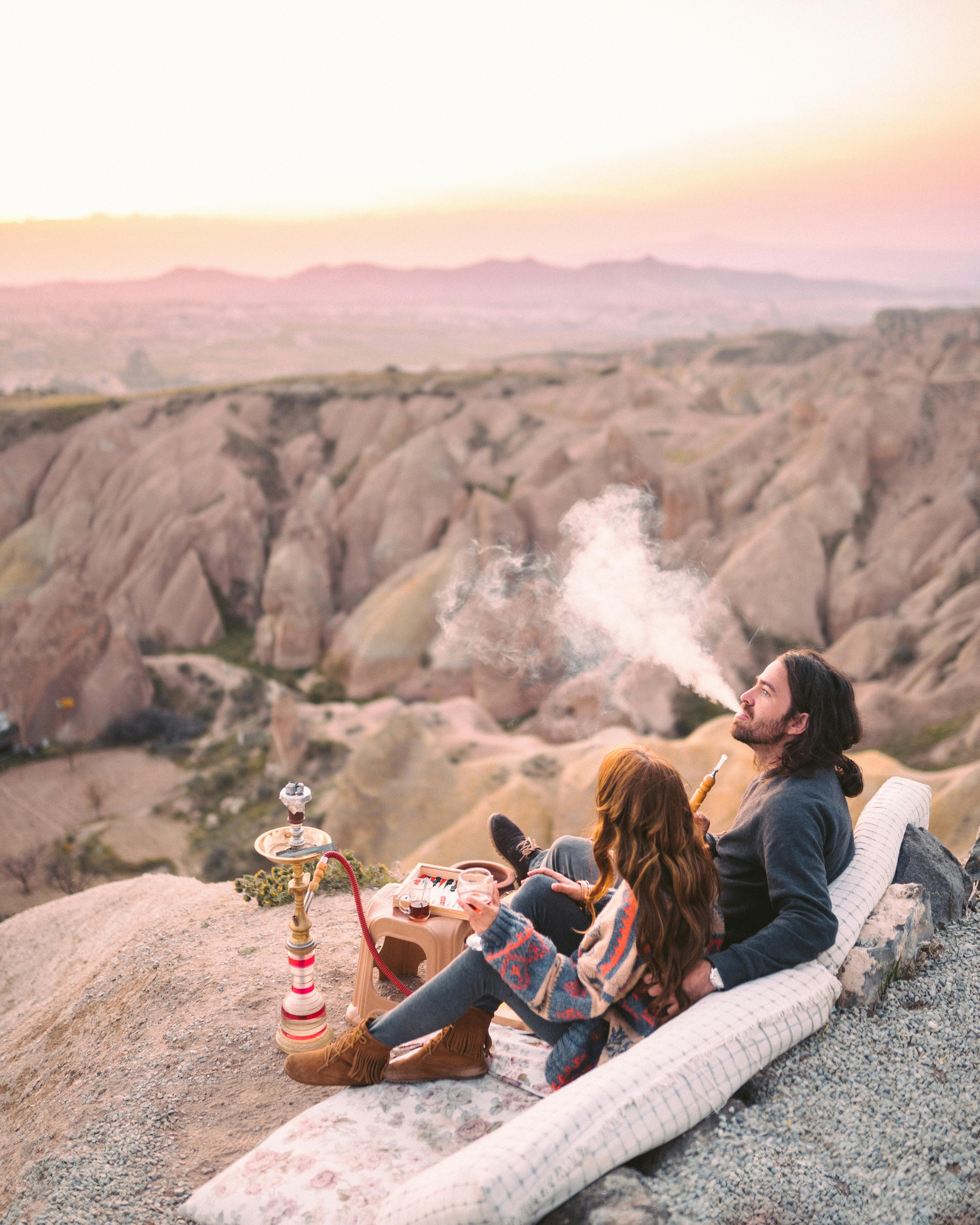 people sitting on pillows using shisha