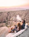 People Sitting On Pillows Using Shisha