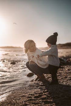 日落时分，一对母子在温暖的海滩岸边分享着温柔的时刻