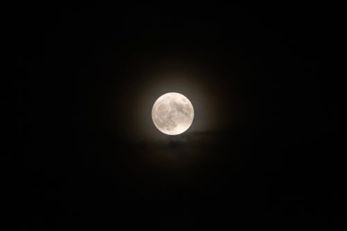 Free Stunning full moon captured in the night sky over Mossa, Italy. Stock Photo