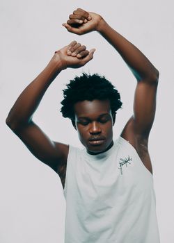 A young man in a dynamic pose with arms raised, exuding confidence.