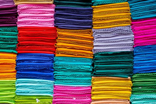 Free Vibrant and colorful stack of folded textiles in various hues, arranged neatly. Stock Photo
