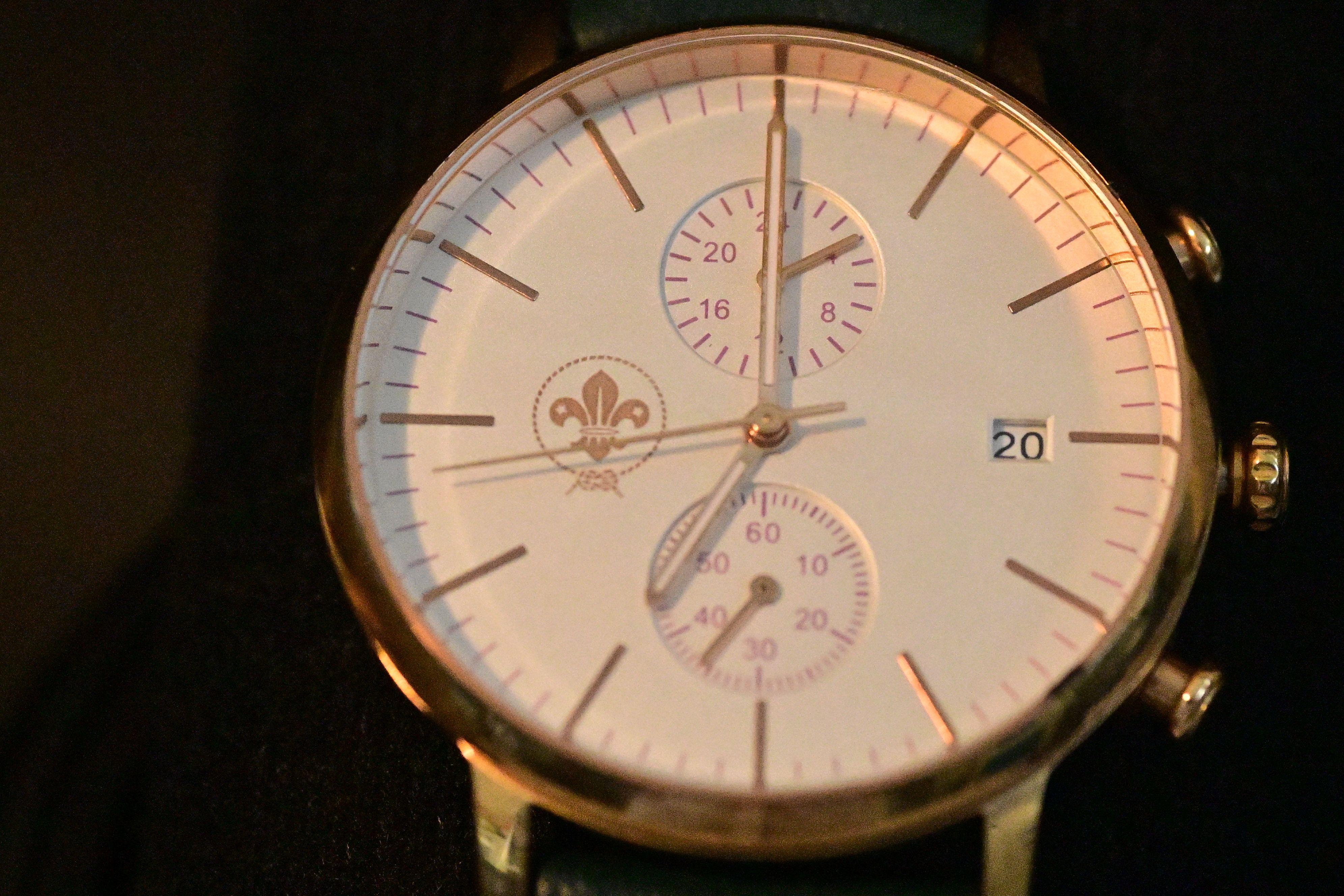 Close-up of an elegant gold wristwatch with chronograph features and a date display.