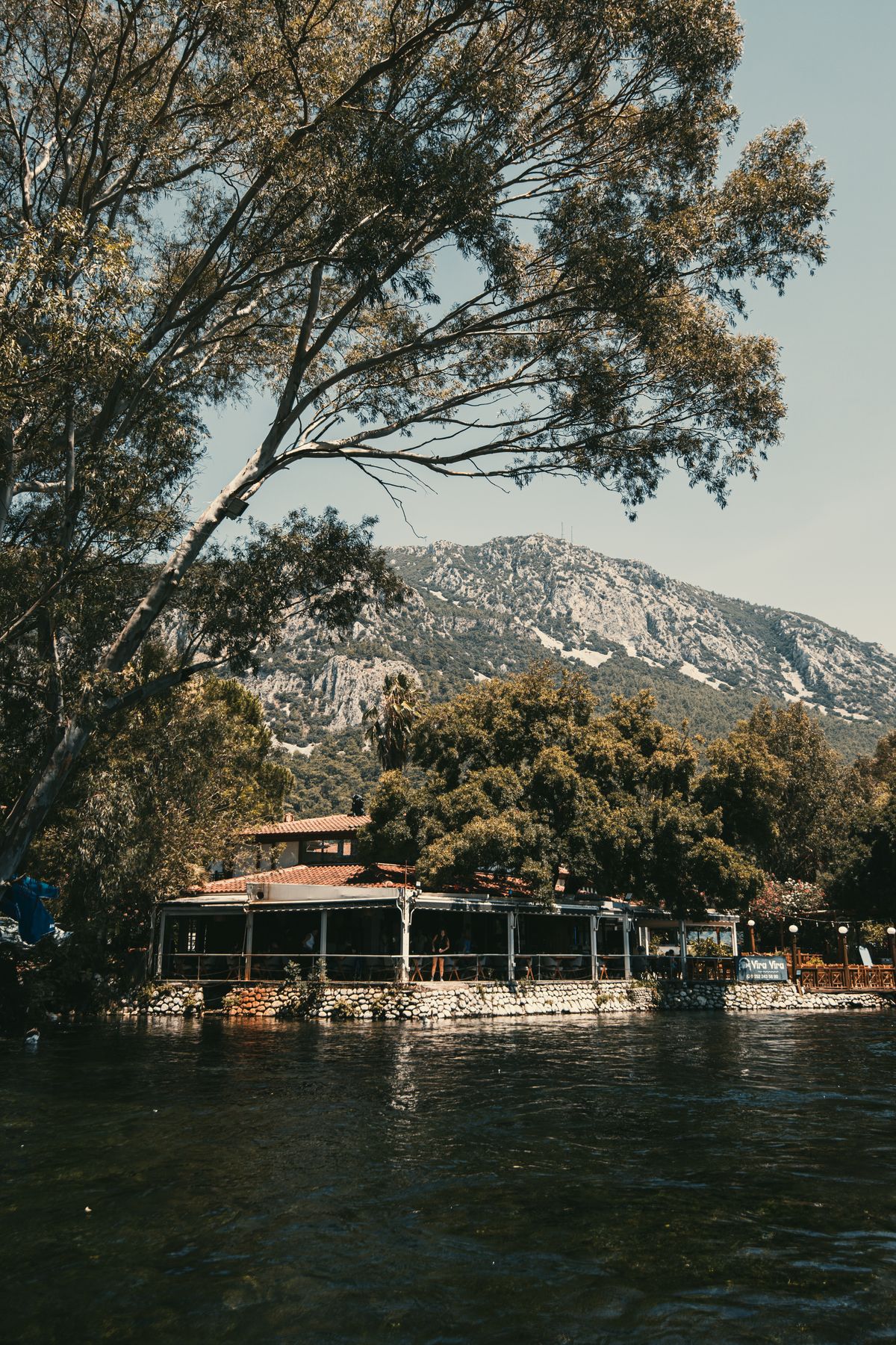 Scenic riverside restaurant surrounded by nature, representative image for Natura Art