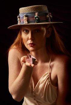 一位女士的时尚肖像，她头戴装饰遮阳帽，手持几何雕塑