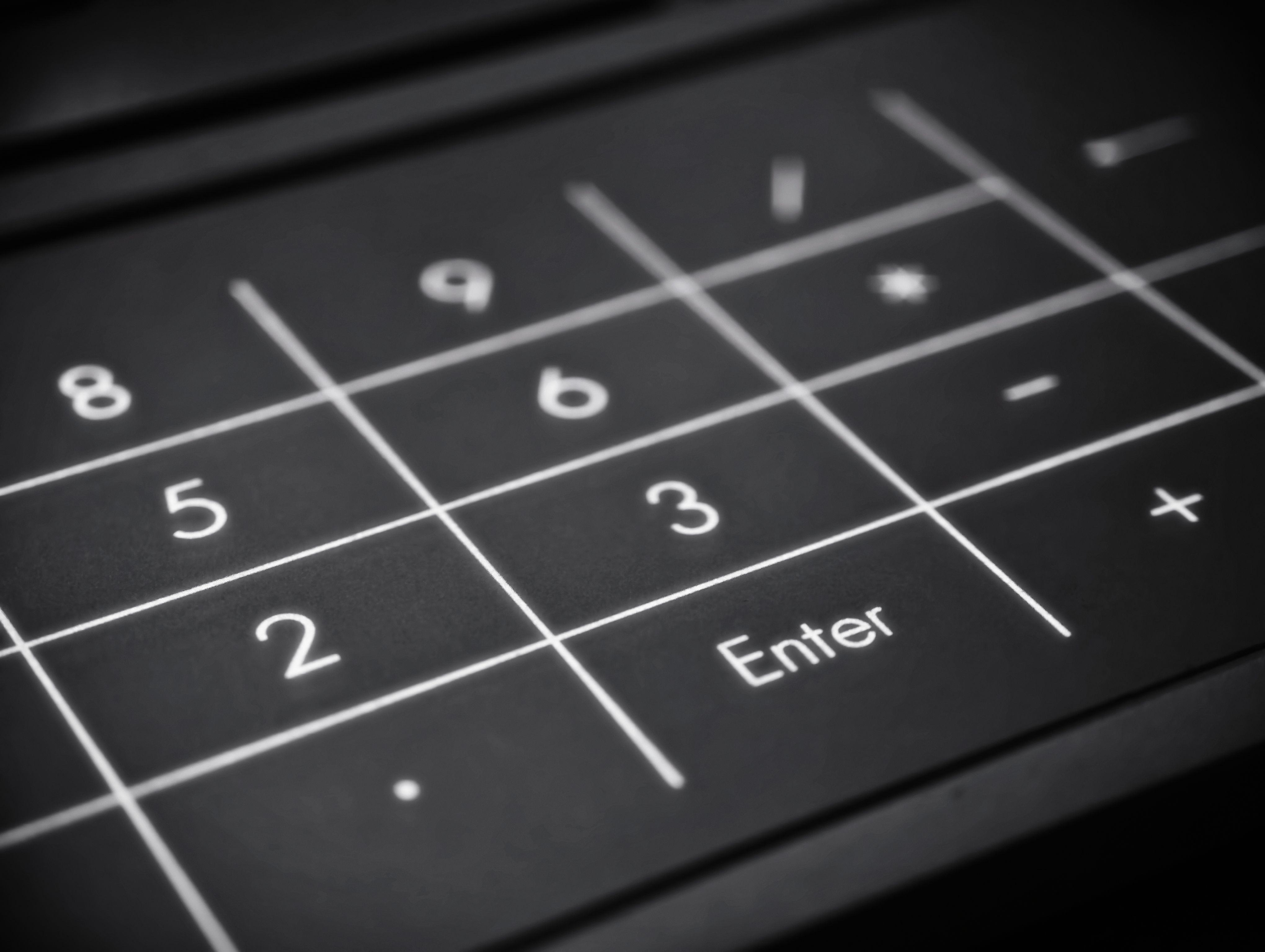 Black and white image of a numeric keypad highlighting the Enter key.