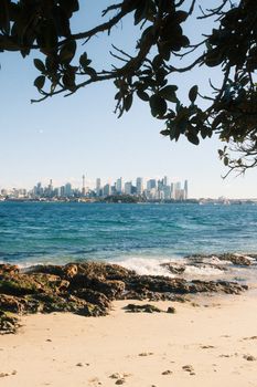Captivating beach view overlooking Sydney's iconic skyline on a sunny day.