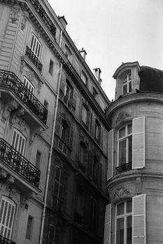 Charming Parisian buildings with classic shutters and ornate balconies in monochrome.