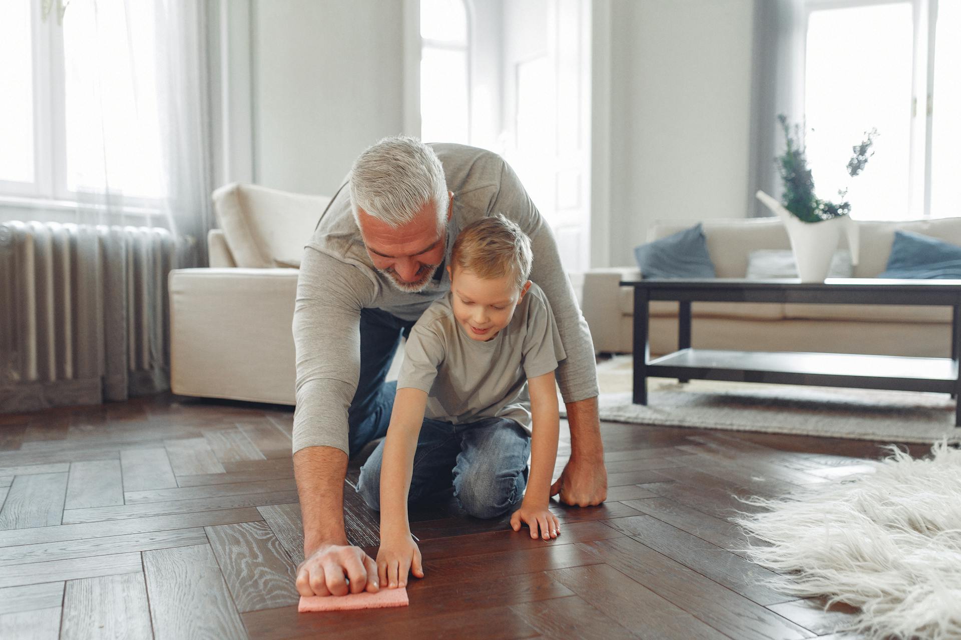 Man In Gray Crew Neck T-shirt And Denim Jeans Wiping Wooden Floor