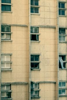 Exterior view of a vintage apartment building showcasing repeated windows and aged facade.