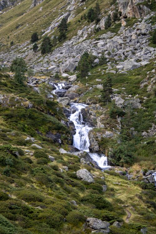 Free Serene view of cascading waterfalls among rocky mountains and greenery. Stock Photo