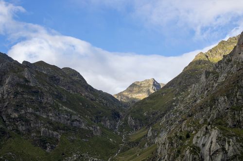 Free A breathtaking view of a mountain range with clear blue skies and scattered clouds, capturing nature's tranquility. Stock Photo