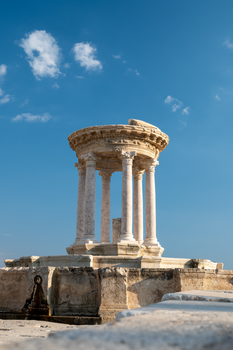 A beautiful nymphaeum with Corinthian columns under a clear blue sky in Burdur, Türkiye.