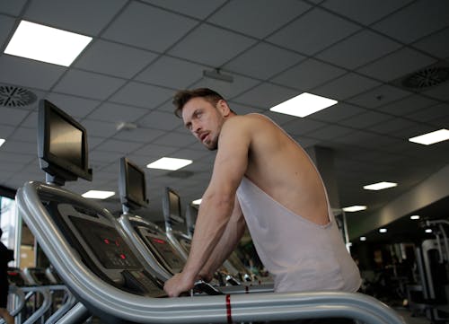 Free Man in White Tank Top Standing on Treadmill Stock Photo