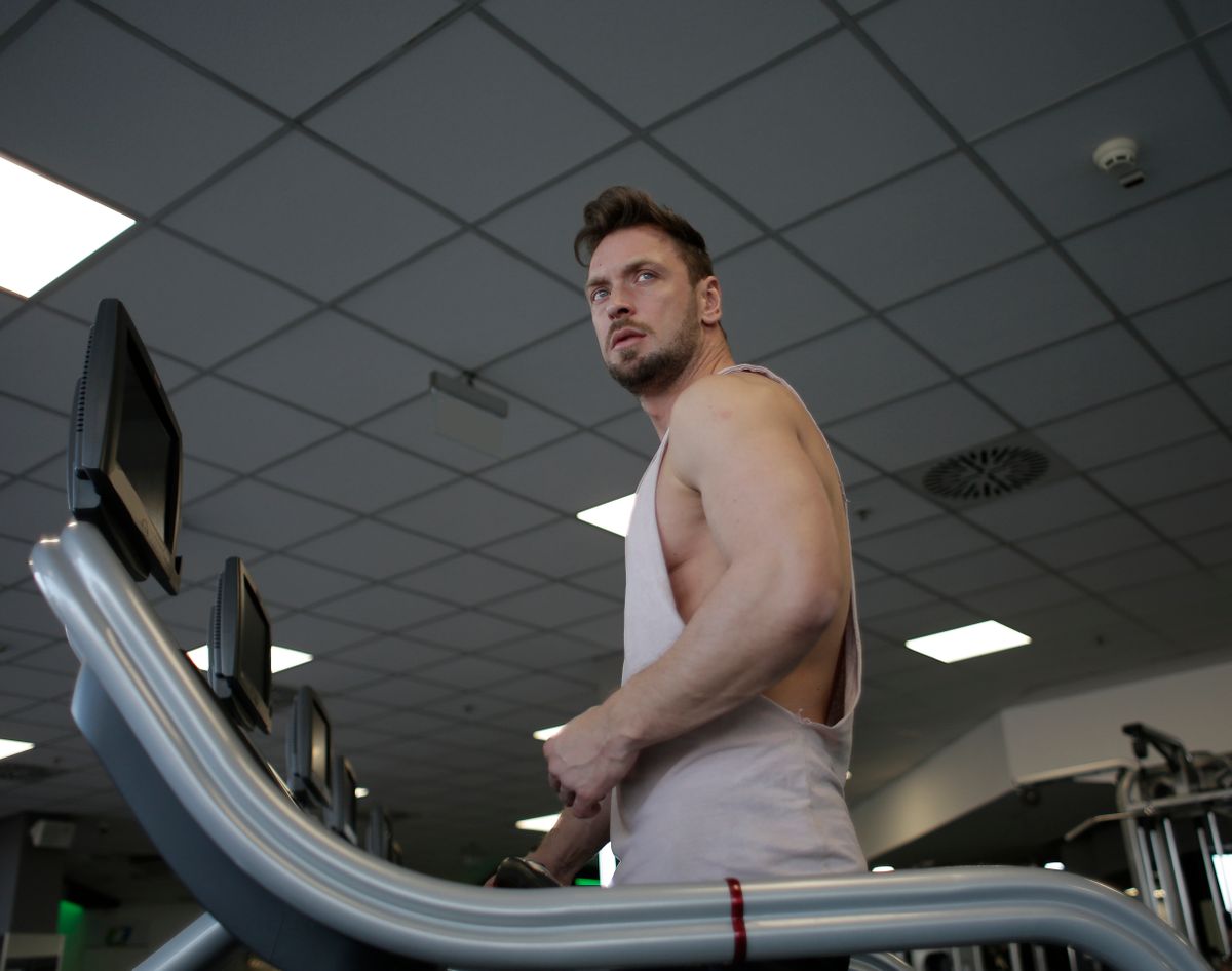 Athletic man training on a treadmill in a modern gym