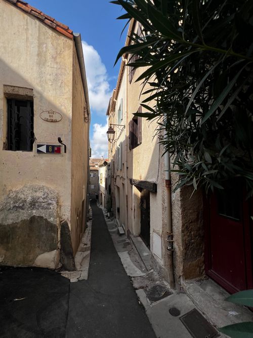 Free Narrow rustic alleyway with vintage architecture in Europe under a bright blue sky. Stock Photo