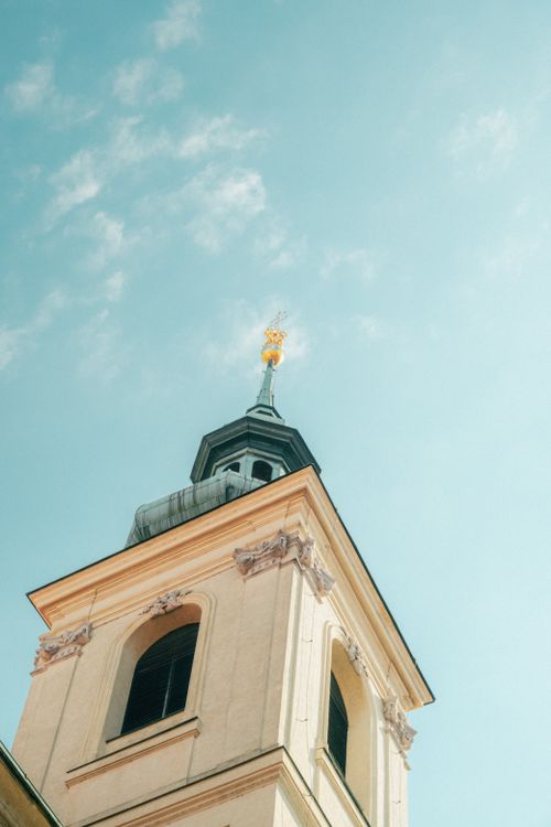 Free Close-up view of a historic church steeple with a cross against a bright blue sky, evoking a sense of serenity. Stock Photo