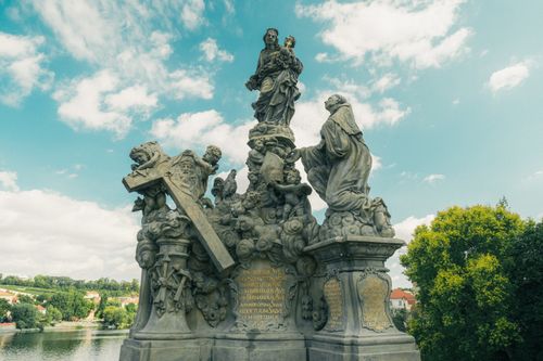 Free Beautiful statues on Charles Bridge in Prague, depicting religious figures with intricate details and scenic background. Stock Photo