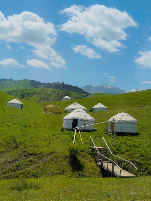Free Explore the picturesque landscape of Kyrgyzstan with traditional yurts under a clear sky. Stock Photo