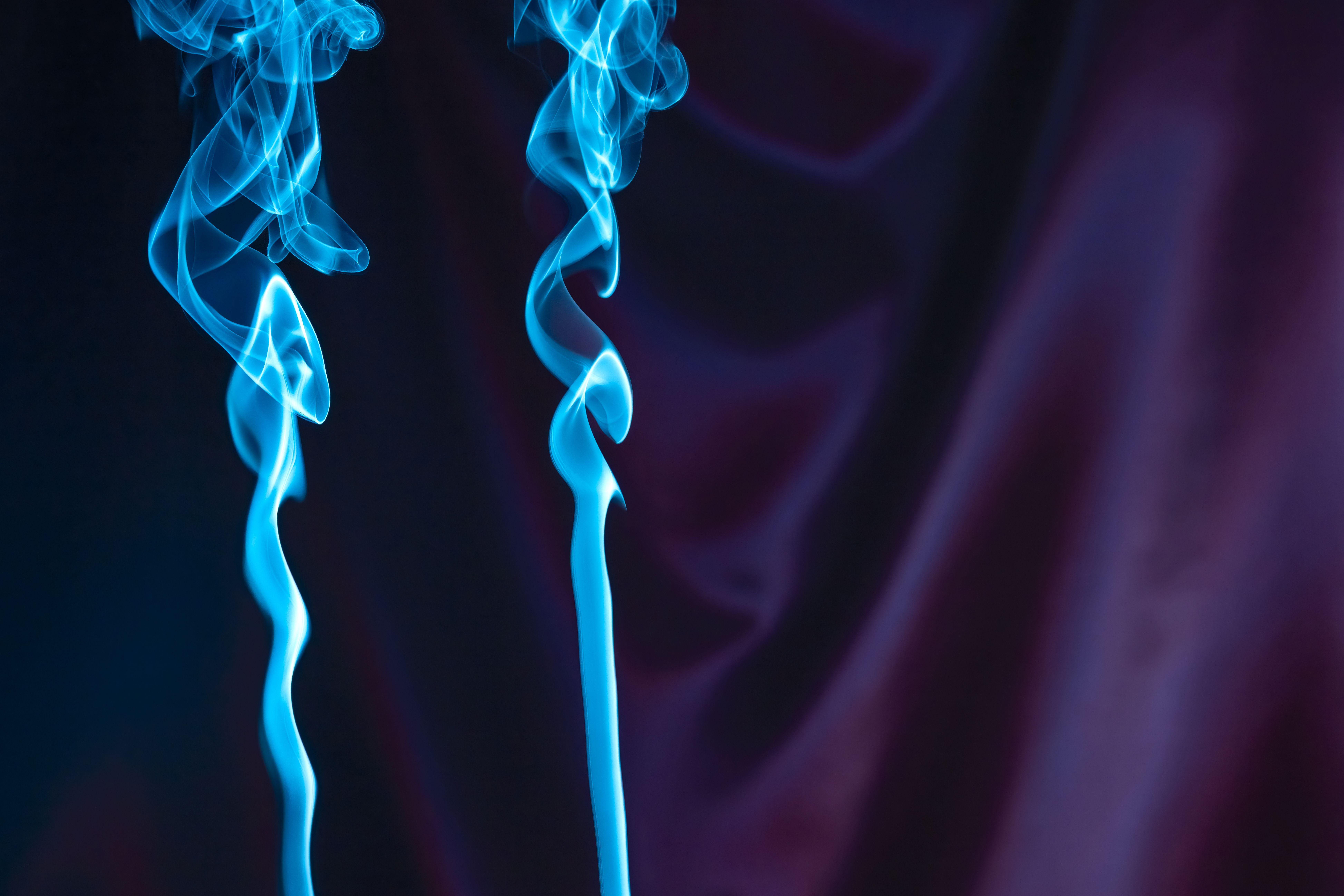 Fotomural Elegantes remolinos de humo azul se elevan con gracia sobre un fondo oscuro y texturizado. Perfectos para temas artísticos y abstractos.