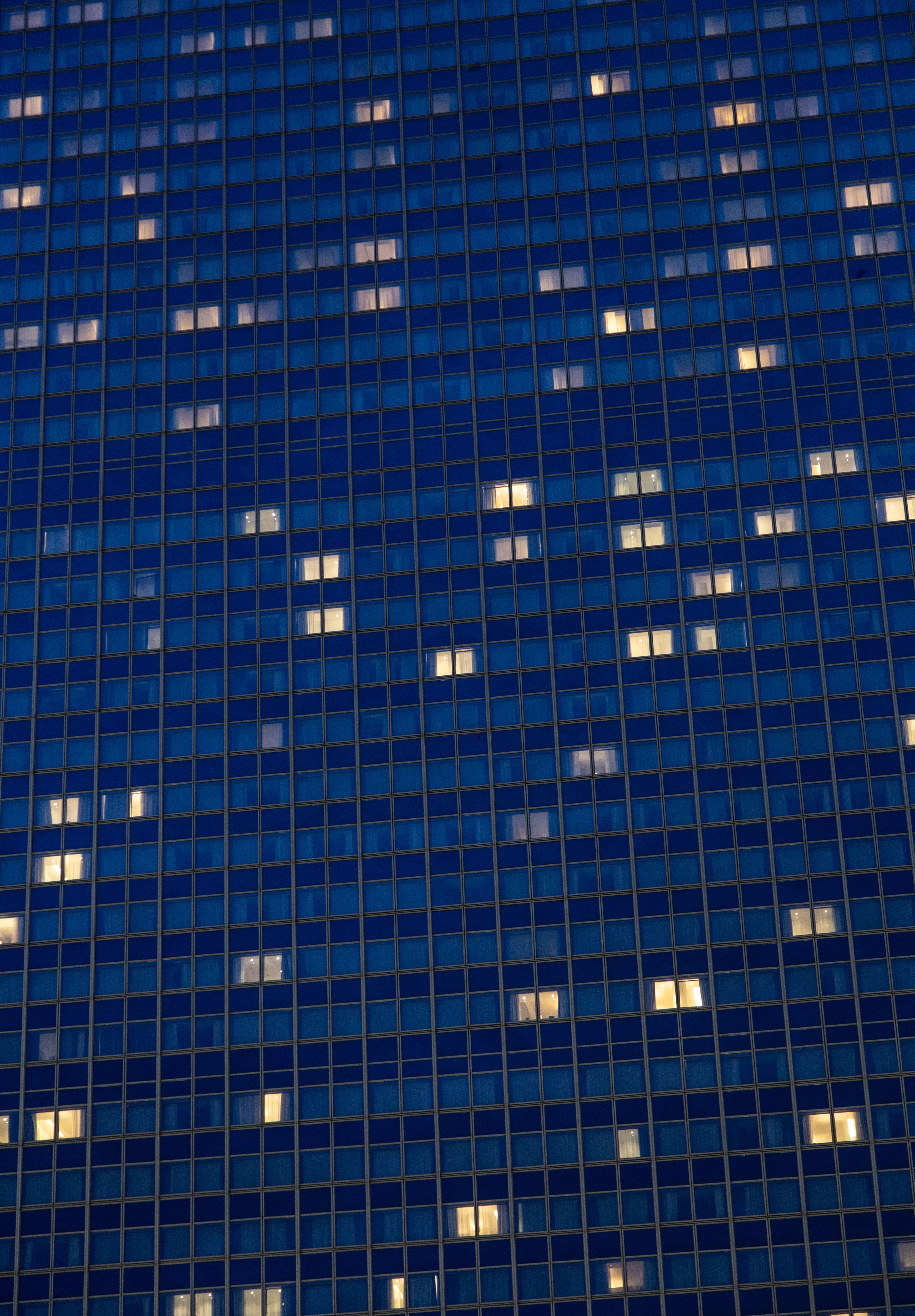 A high-rise building with glowing windows against a night sky, showcasing urban architecture.