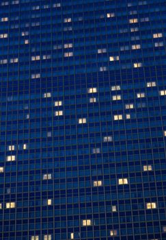 A high-rise building with glowing windows against a night sky, showcasing urban architecture.