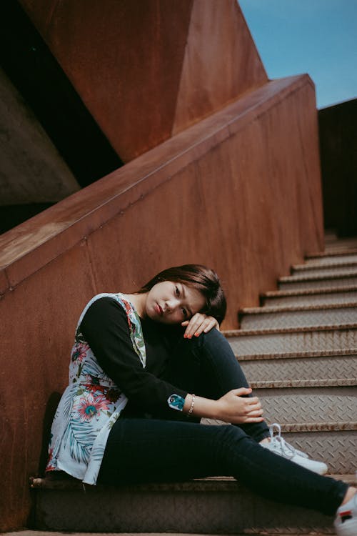 бесплатная Фотография женщины, сидящей на лестнице Стоковое фото