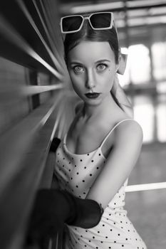 Black and white portrait of a woman in retro fashion with sunglasses.