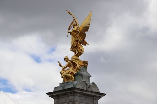 Free A majestic golden statue atop the Victoria Memorial under a dramatic cloudy sky, symbolizing victory and glory. Stock Photo