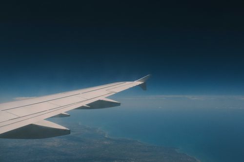 Free A breathtaking aerial view of Lefkada, Greece, showing the wing of an airplane over the ocean and coastline. Stock Photo