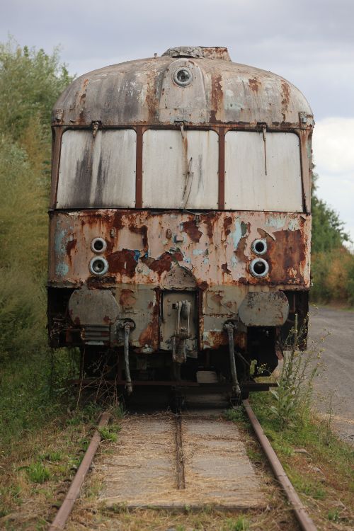 Free An old, rusty train car sits on overgrown tracks, symbolizing decay and nostalgia. Stock Photo