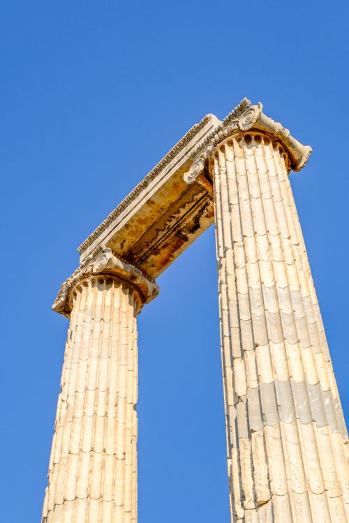 Free Two ancient Greek columns under a clear blue sky, capturing historical architecture. Stock Photo