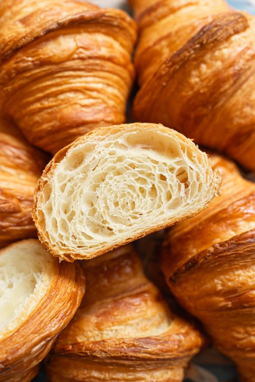 Free Appetizing close-up of freshly baked croissants with a detailed view of flaky layers. Stock Photo