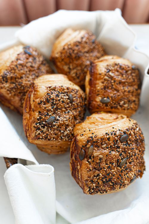 Free Appetizing freshly baked croissants with seeds on display in a basket, ready to serve. Stock Photo