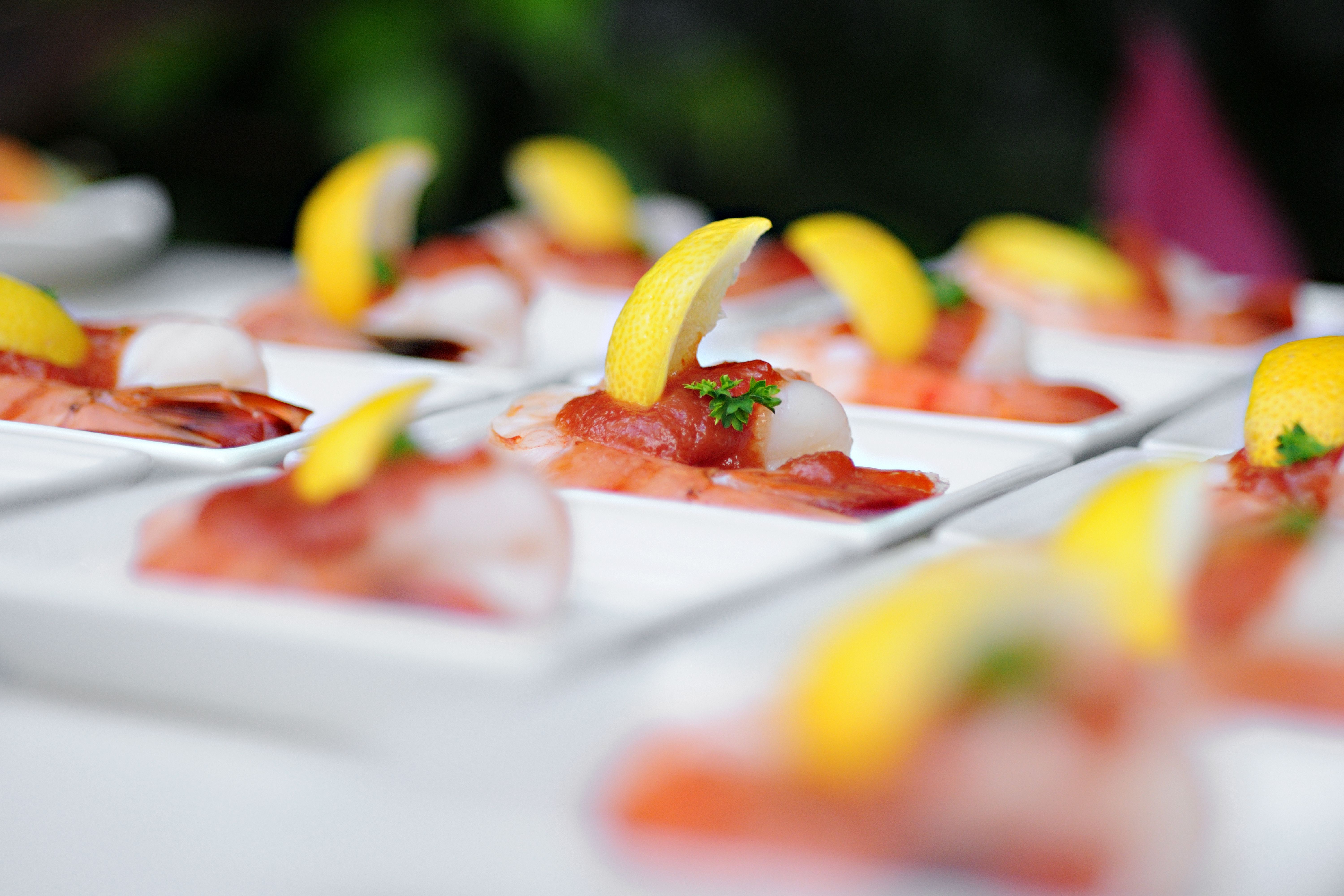 Appetizing shrimp cocktails garnished with lemon slices and parsley, arranged on white plates.